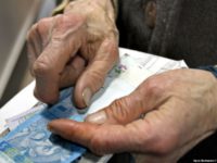 руки пожилой женщины с деньгами